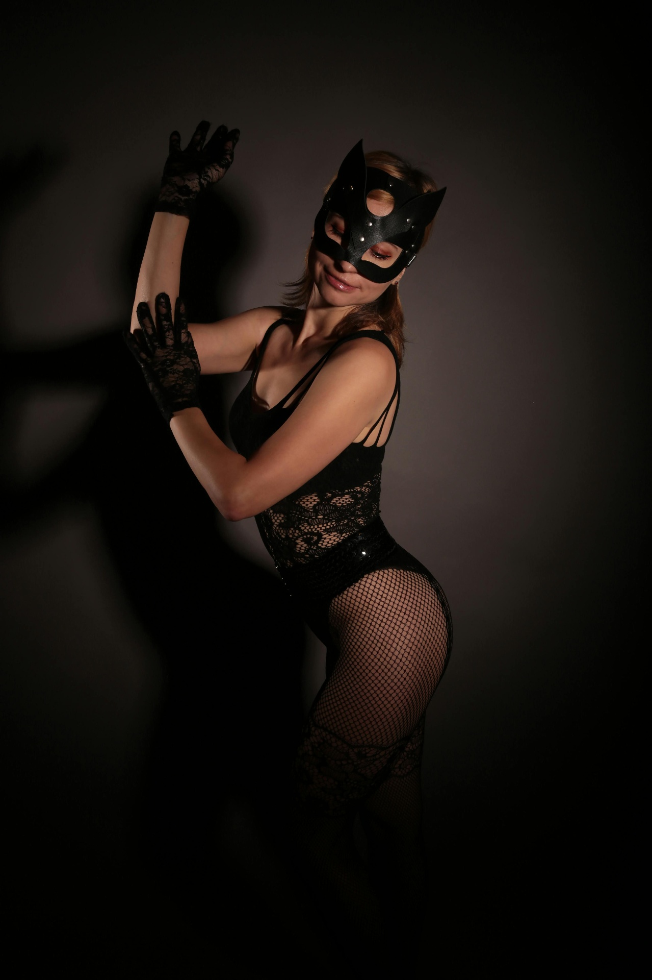 Masked performer in lace and fishnet